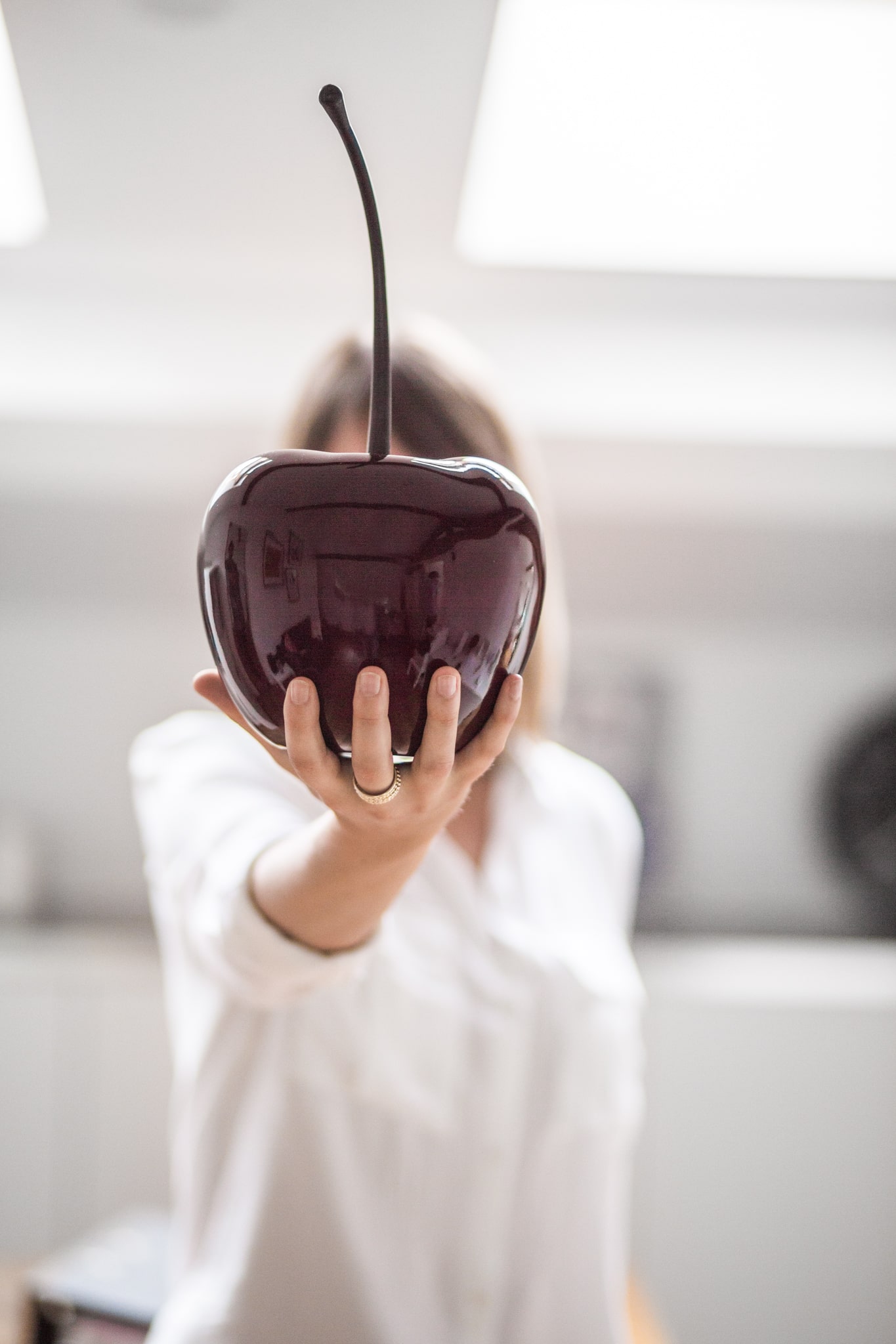 sculpture cerise de l’agence de relation presse la Cerise dans la main d’une attachée de presse